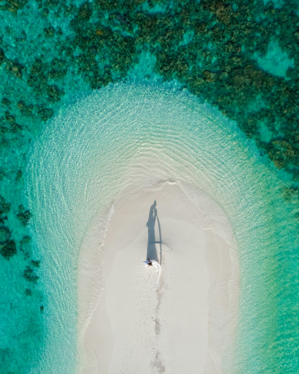 an aerial view of a person standing on a beach
