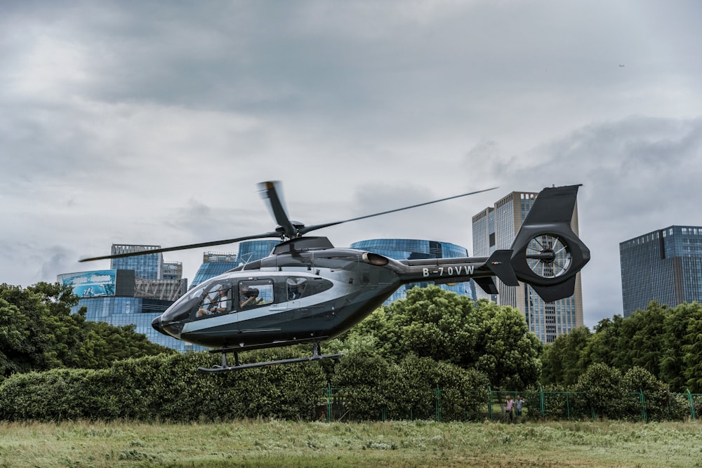 gray and black helicopter flying over the ground