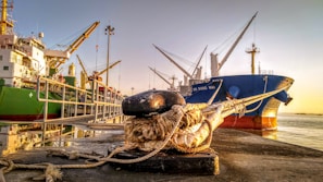 Team of supervisors and workers engaged in mooring and lashing activities on a dry cargo vessel at dusk.