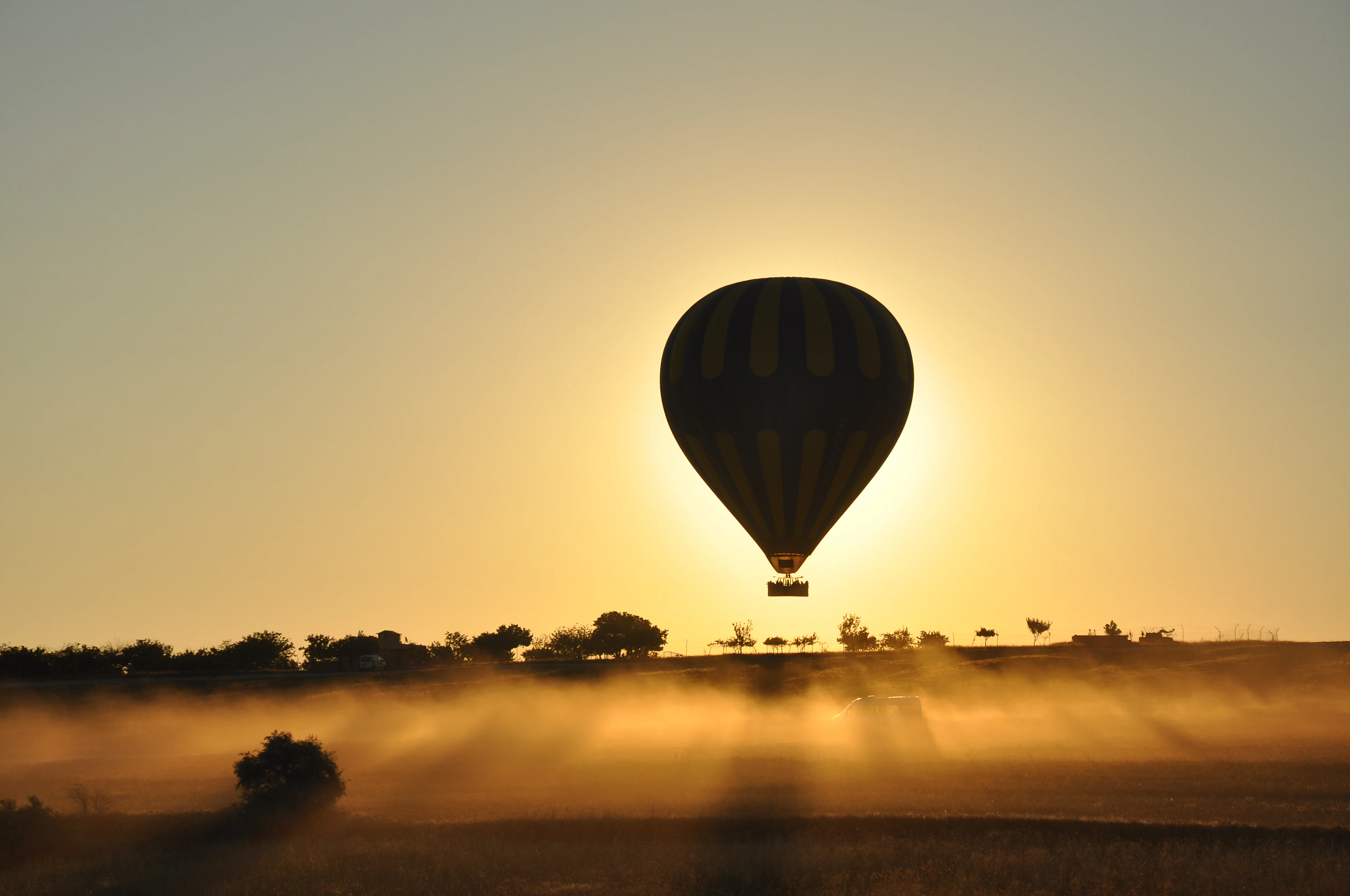 Hot air balloon silhouetted against a sunrise