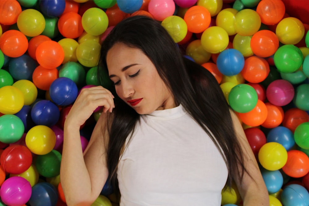 a woman standing in front of a pile of colorful balls