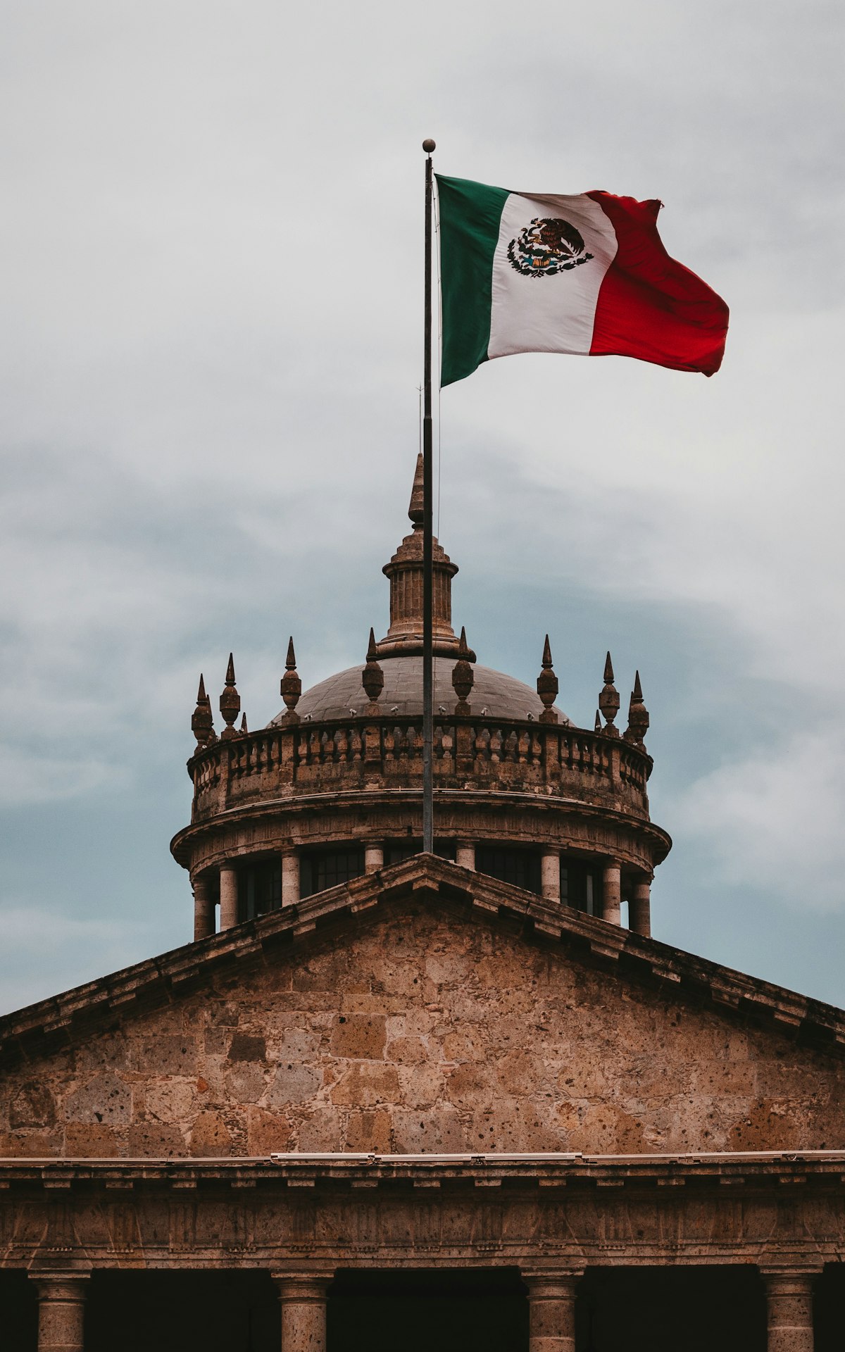 The dome of Hospicio Cabañas in Guadalajara's Centro Histórico with a Mexican flag flying above