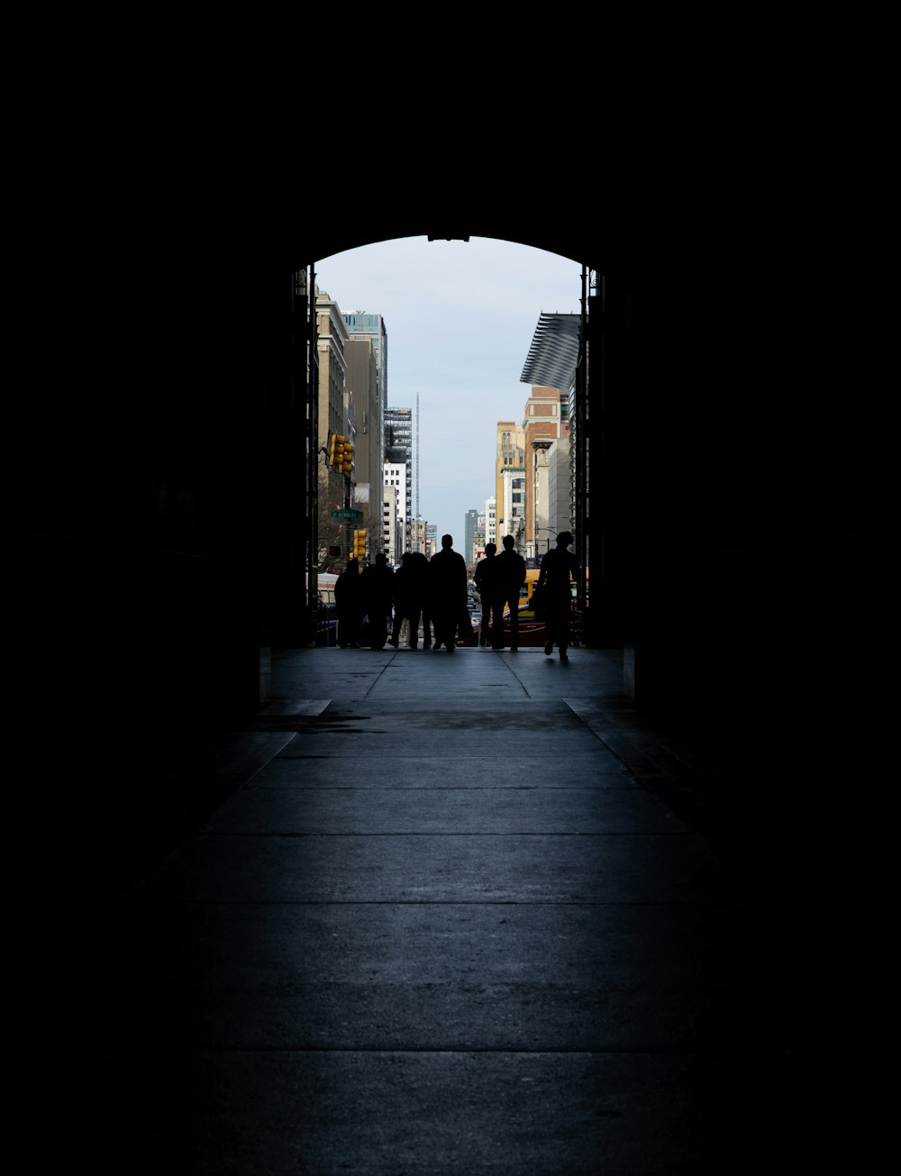 silhouette of people walking in tunnel