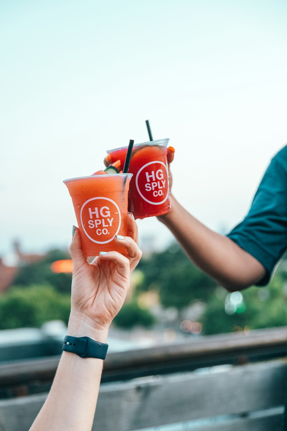 person holding two cold drinks