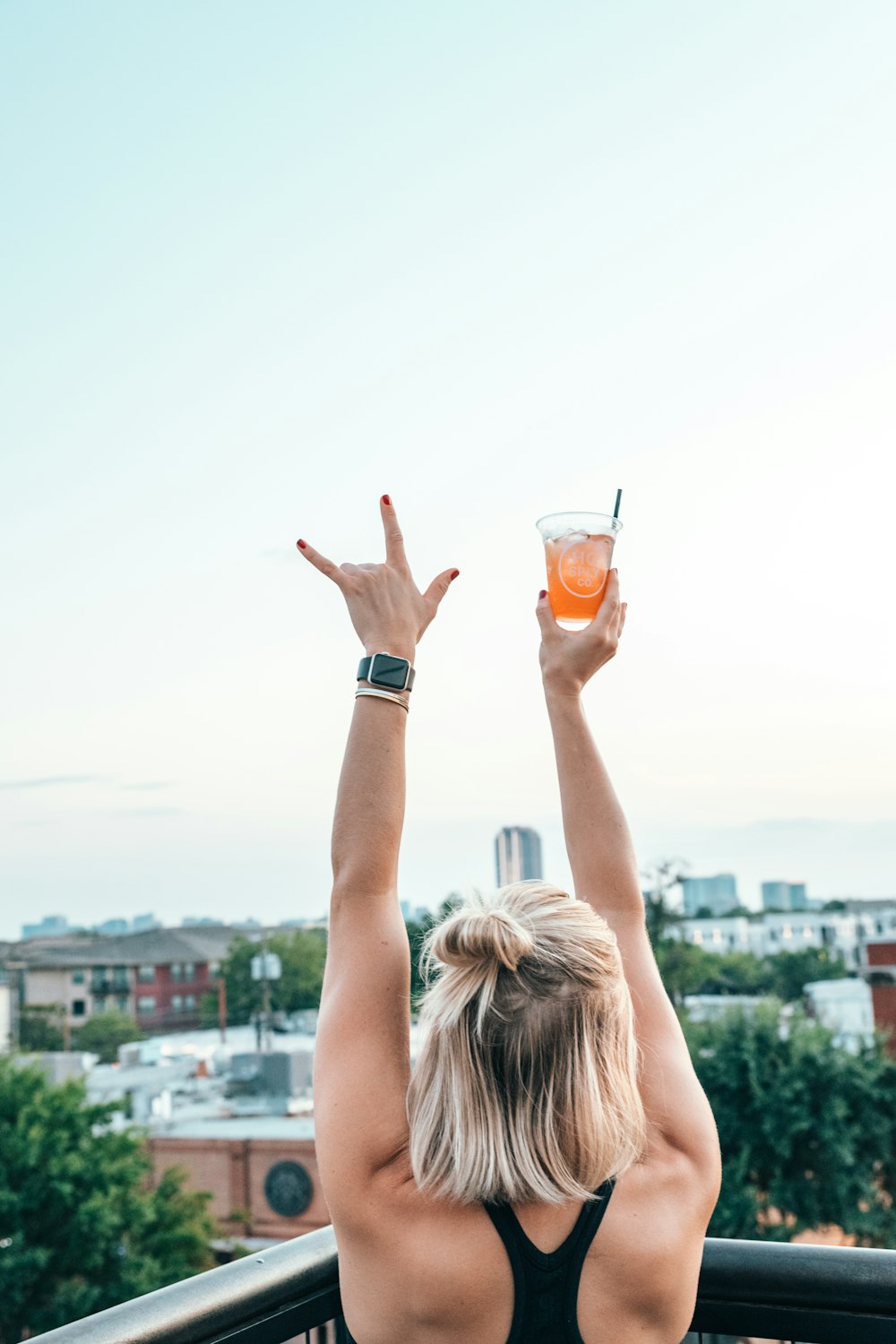 mujer levantando la mano sosteniendo un vaso