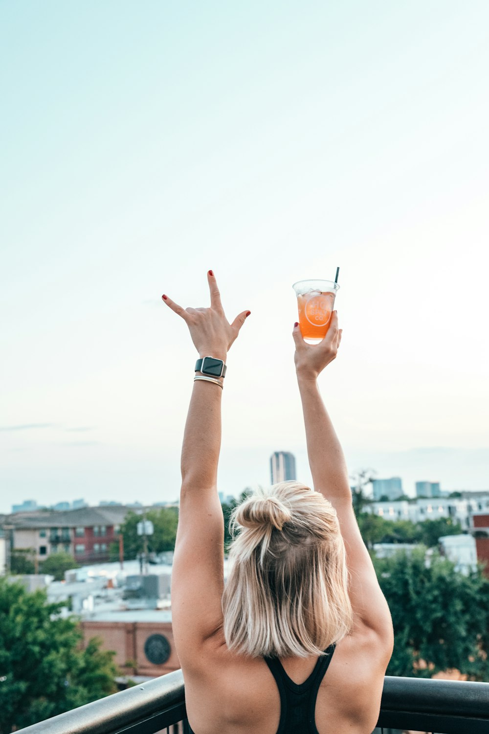 woman raising hand holding drinking glass