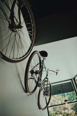 Stationary bike positioned by a large window overlooking greenery.