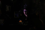 Host Nathaniel King narrating a folklore tale, his face illuminated by amber light against a dark backdrop.