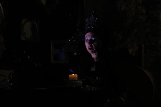 A moody, gold-accented cinematic frame showing a masked figure in a dark, elegant setting.