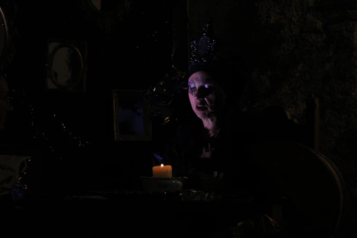 A moody, gold-accented cinematic frame showing a masked figure in a dark, elegant setting.