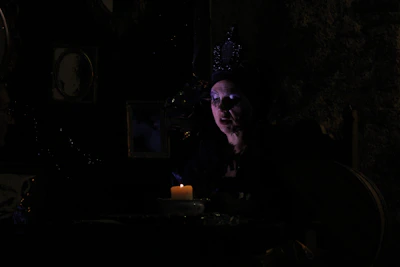 Host Nathaniel King narrating a folklore tale, his face illuminated by amber light against a dark backdrop.
