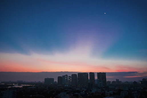 An elegant depiction of planetary orbits overlaying a city skyline at dusk.