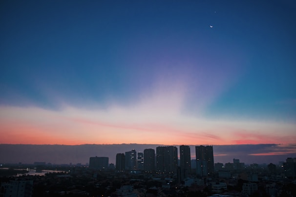 An artistic representation of planets aligning over a professional skyline at dawn.
