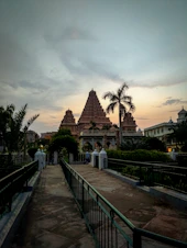 A serene temple courtyard bathed in soft golden light, with a gentle breeze rustling peacock feathers nearby.