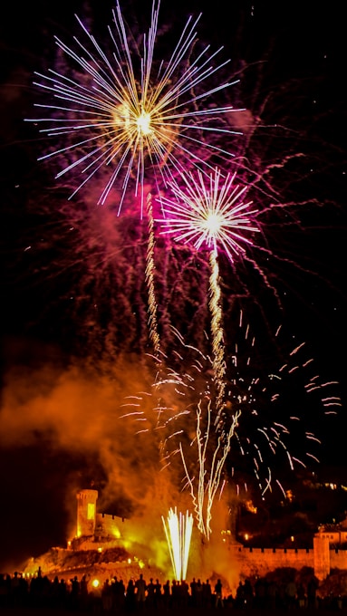 a large fireworks display with a castle in the background