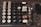 An old, vintage cash register with large, mechanical buttons displaying different denominations of money from $1 to $60. The cash register features buttons for functions like 'NO SALE', 'TAX', and 'LIST'. There are keys resting near the lower right corner of the cash register.