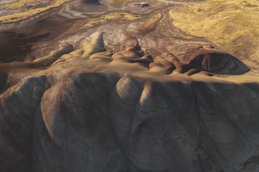 an aerial view of a mountain with yellow grass