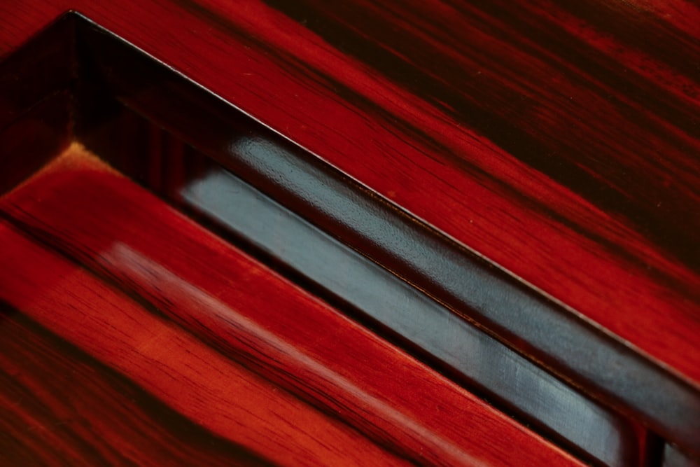a close up of a red wooden surface