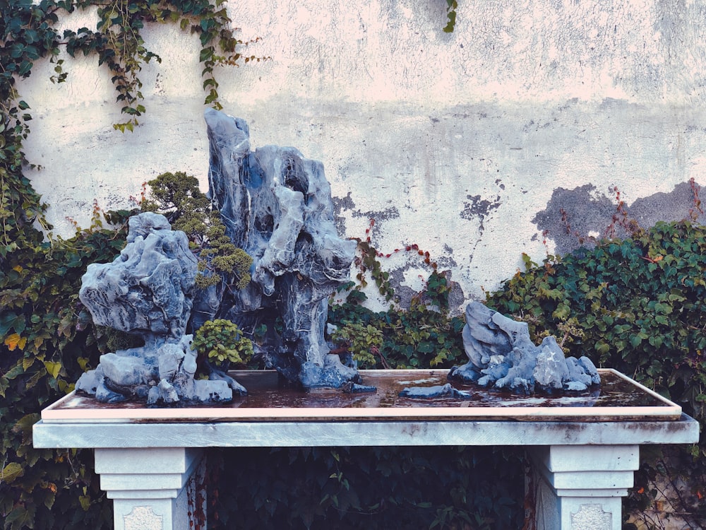 une table avec des statues dessus devant un mur