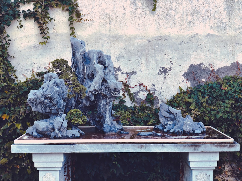 a table with statues on top of it in front of a wall
