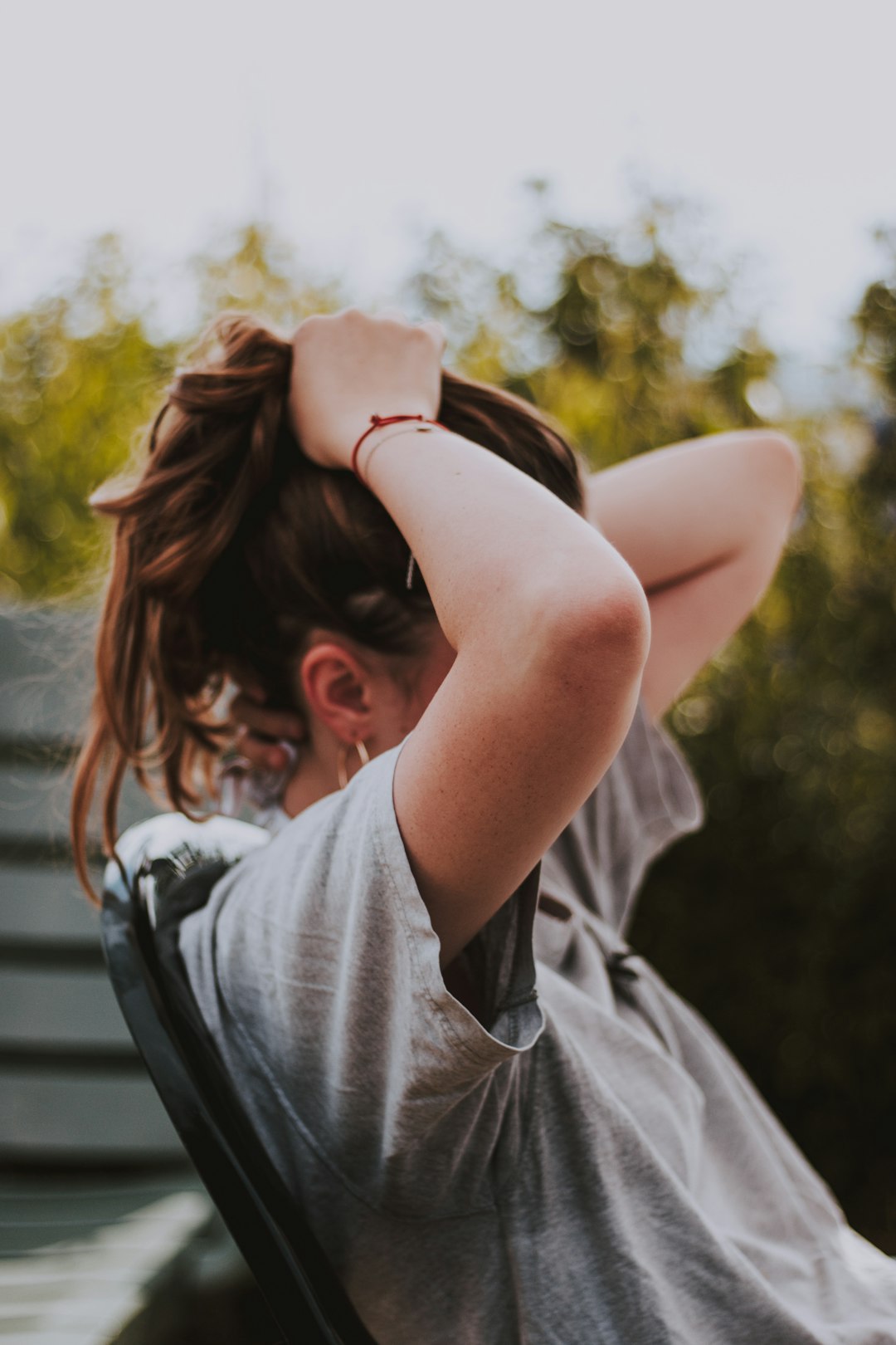 selective focus photography of sitting woman fixing hair