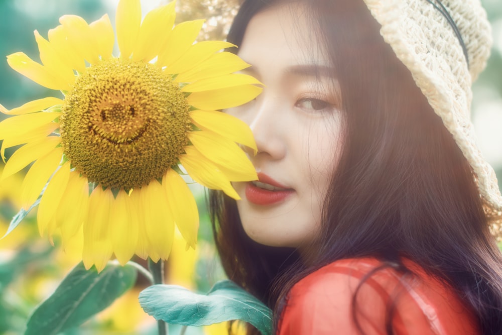woman standing close to yellow smiling sunflower