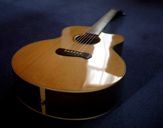 Close-up of a vibrant acoustic guitar resting on a wooden floor