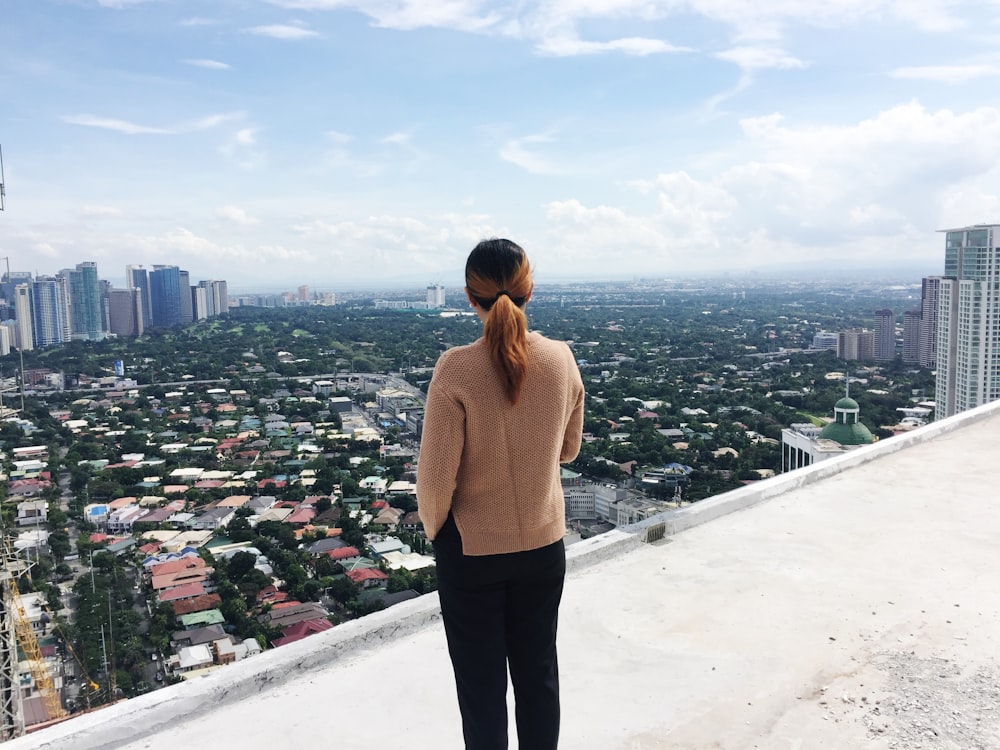 woman standing on roof of building at the city