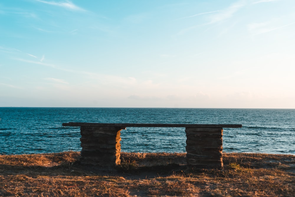 a bench sitting on top of a dry grass covered field