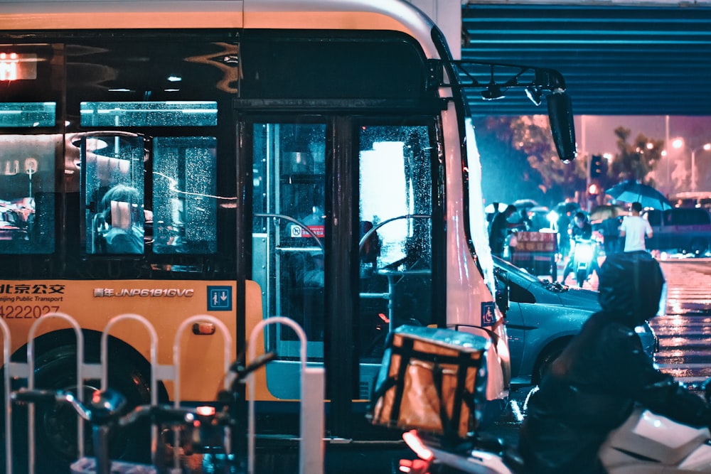 person riding motorcycle near yellow bus