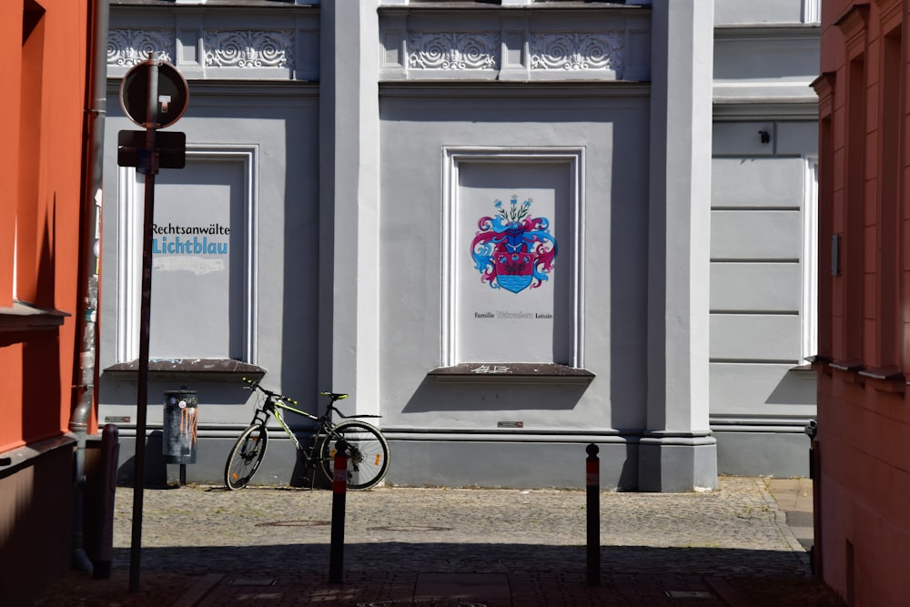 gray bicycle parks beside building