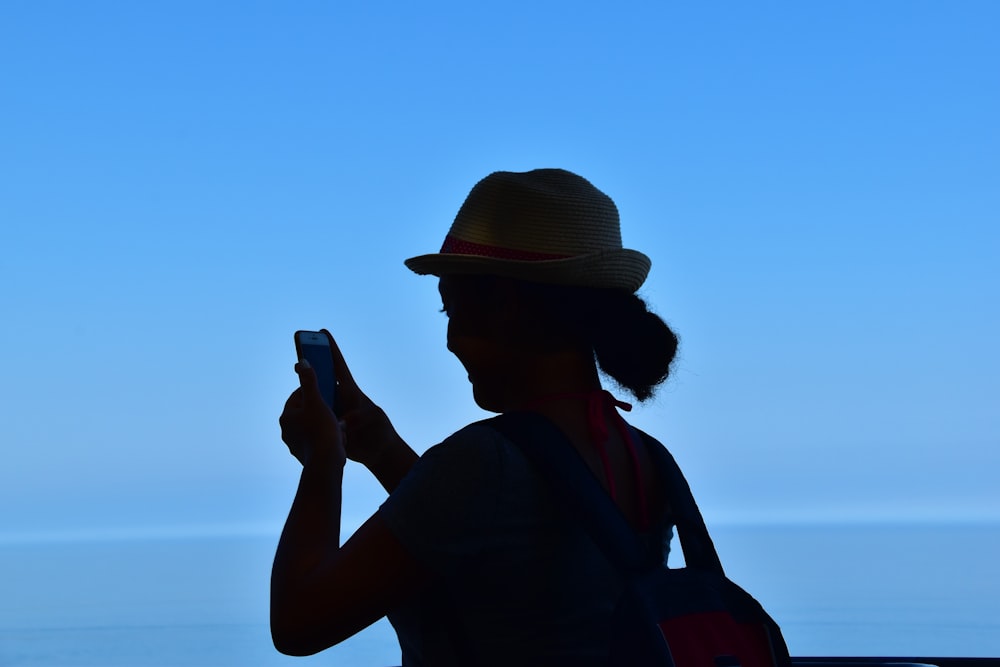 a woman with a hat is looking at her cell phone