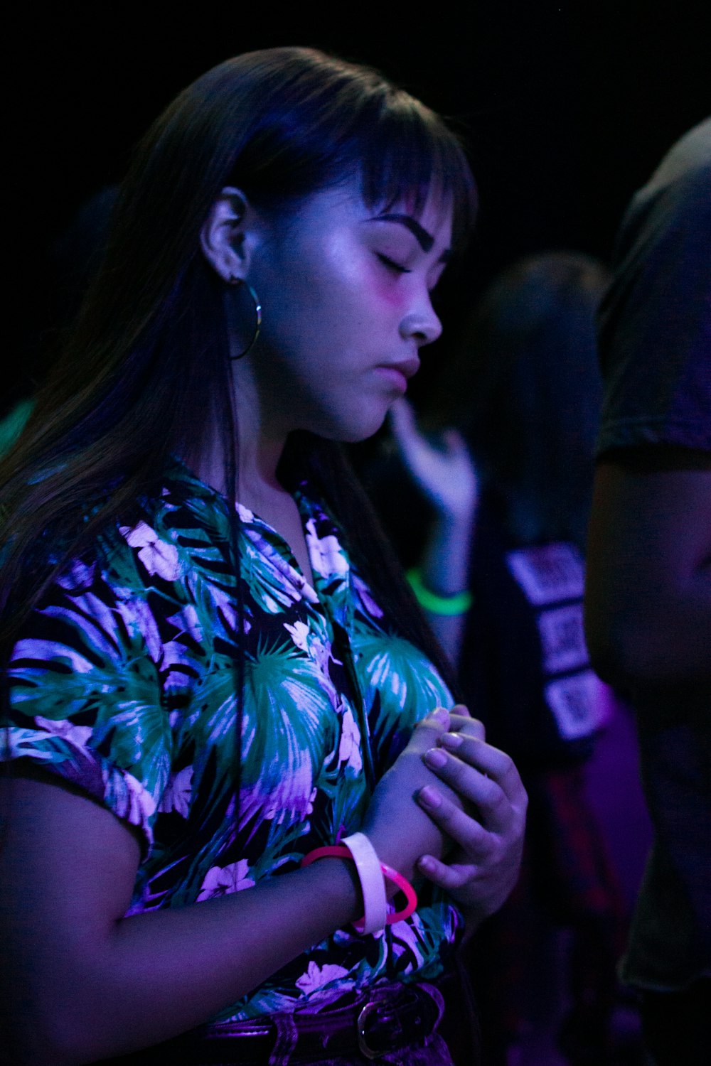 a woman standing in a crowd looking at her cell phone