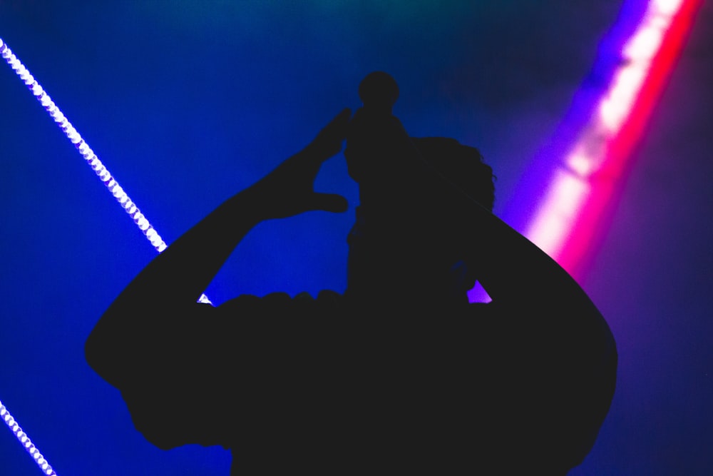silhouette of man holds microphone