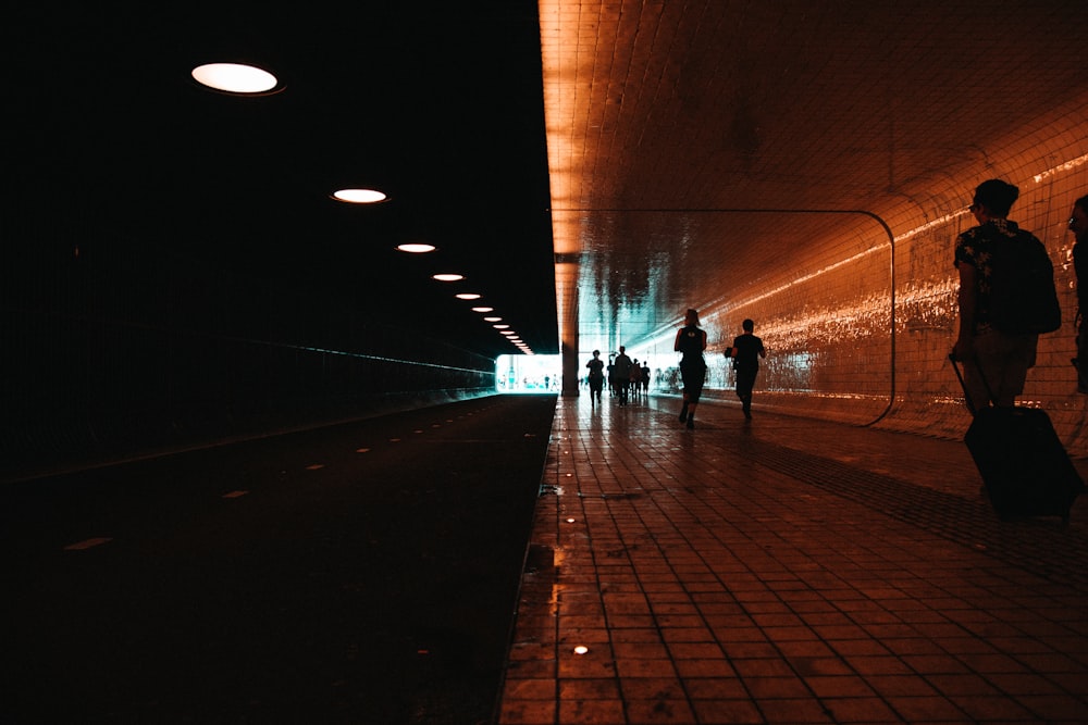 silhouette photography of people walking along train station