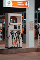 Technician inspecting modern fuel pumps at a gas station during maintenance.