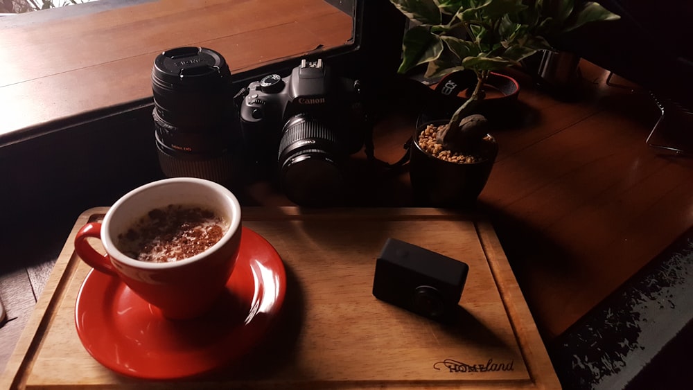 ceramic cup on saucer near DSLR camera