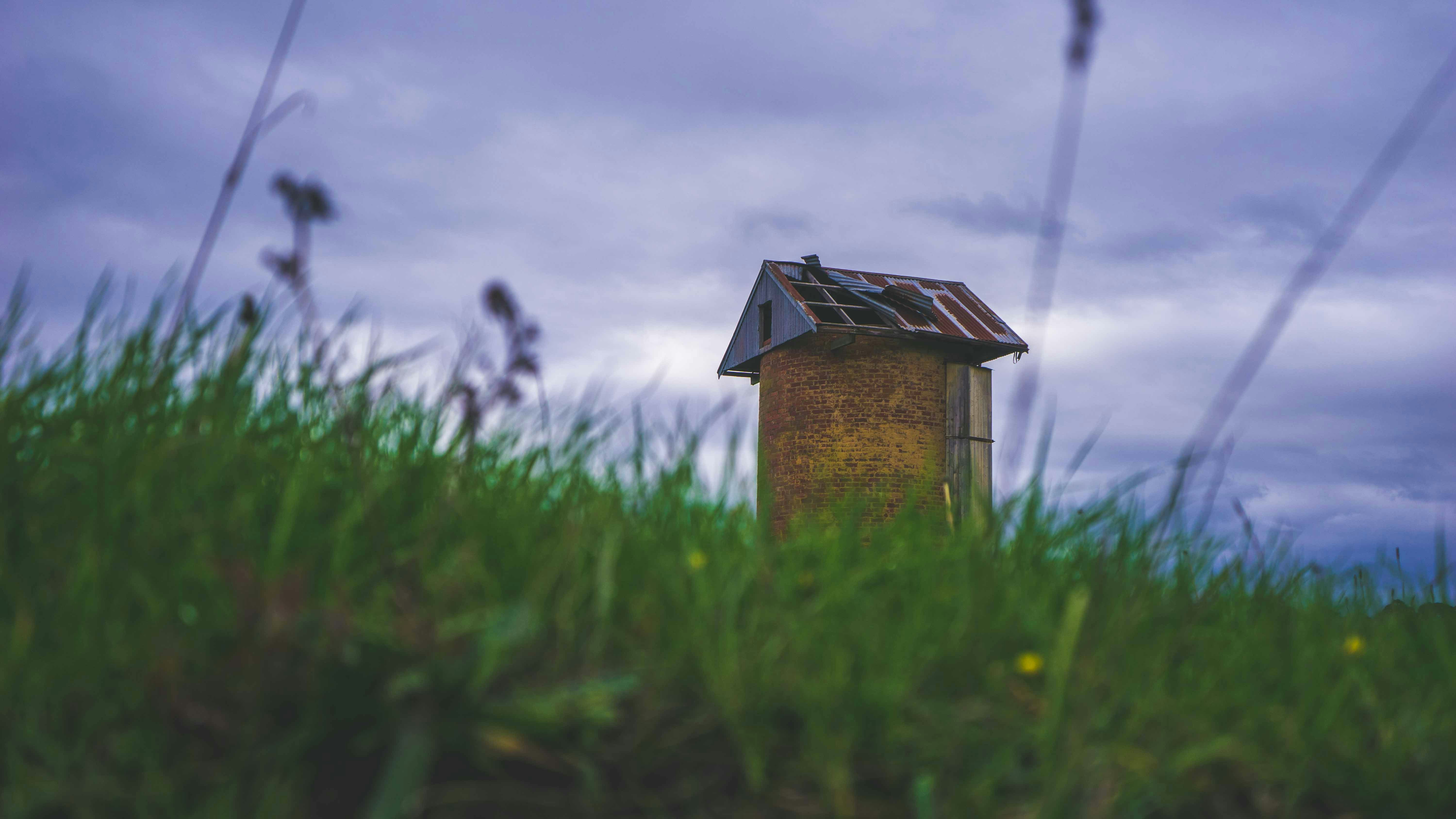 brown wooden shed on green field