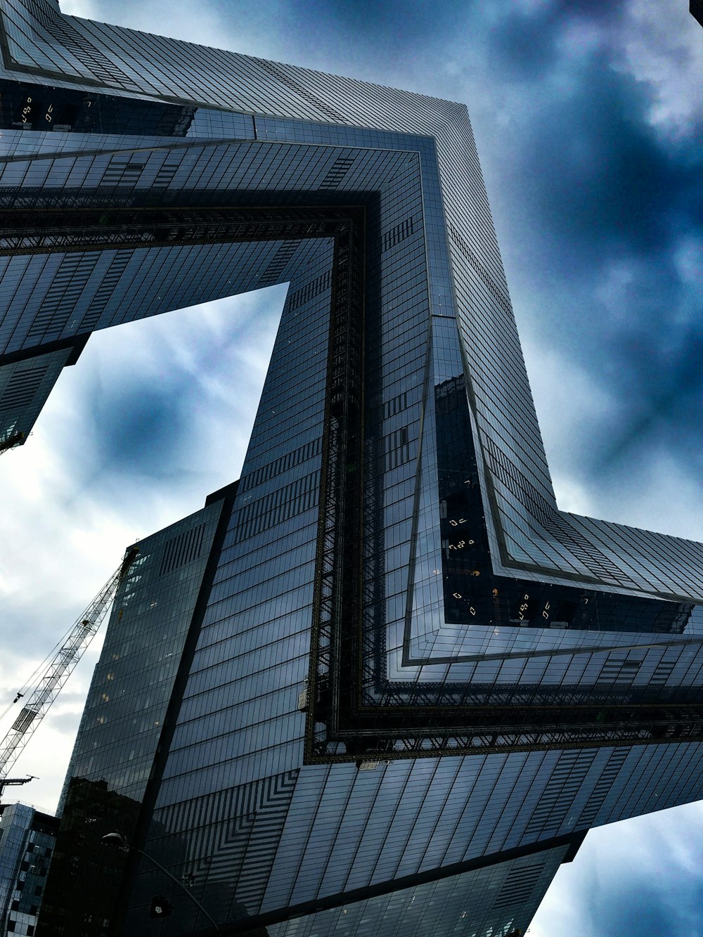 blue glass walled high-rise building under blue and white skies