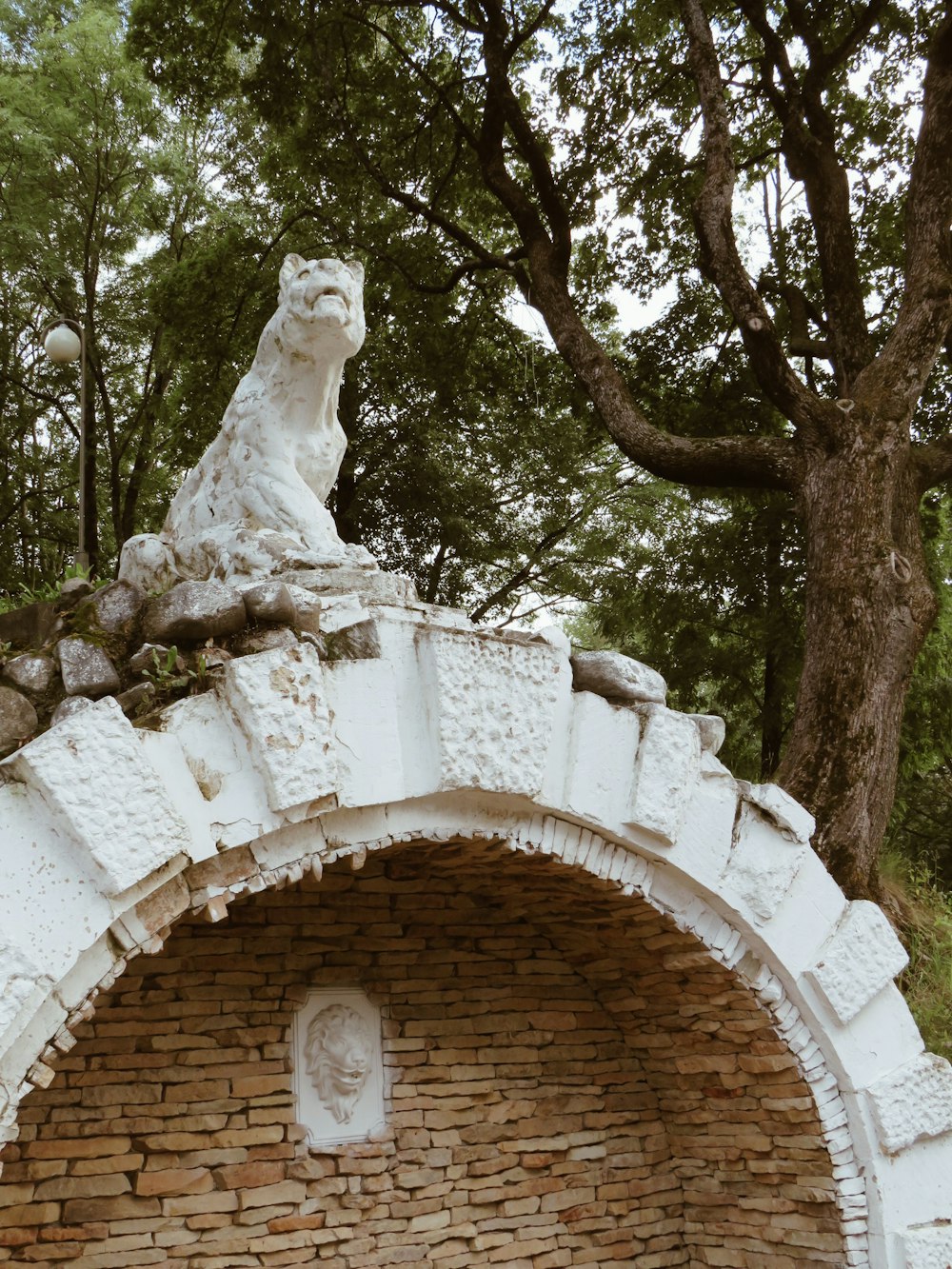 White Animal Mini Statue umgeben von hohen und grünen Bäumen