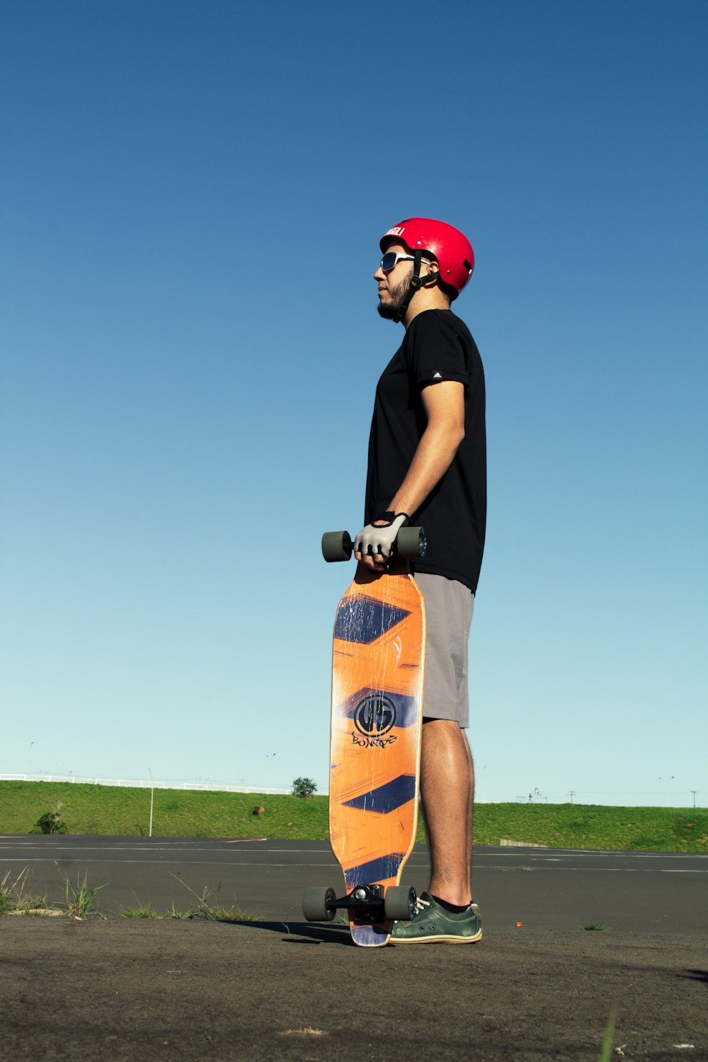 a man holding a skateboard on a road