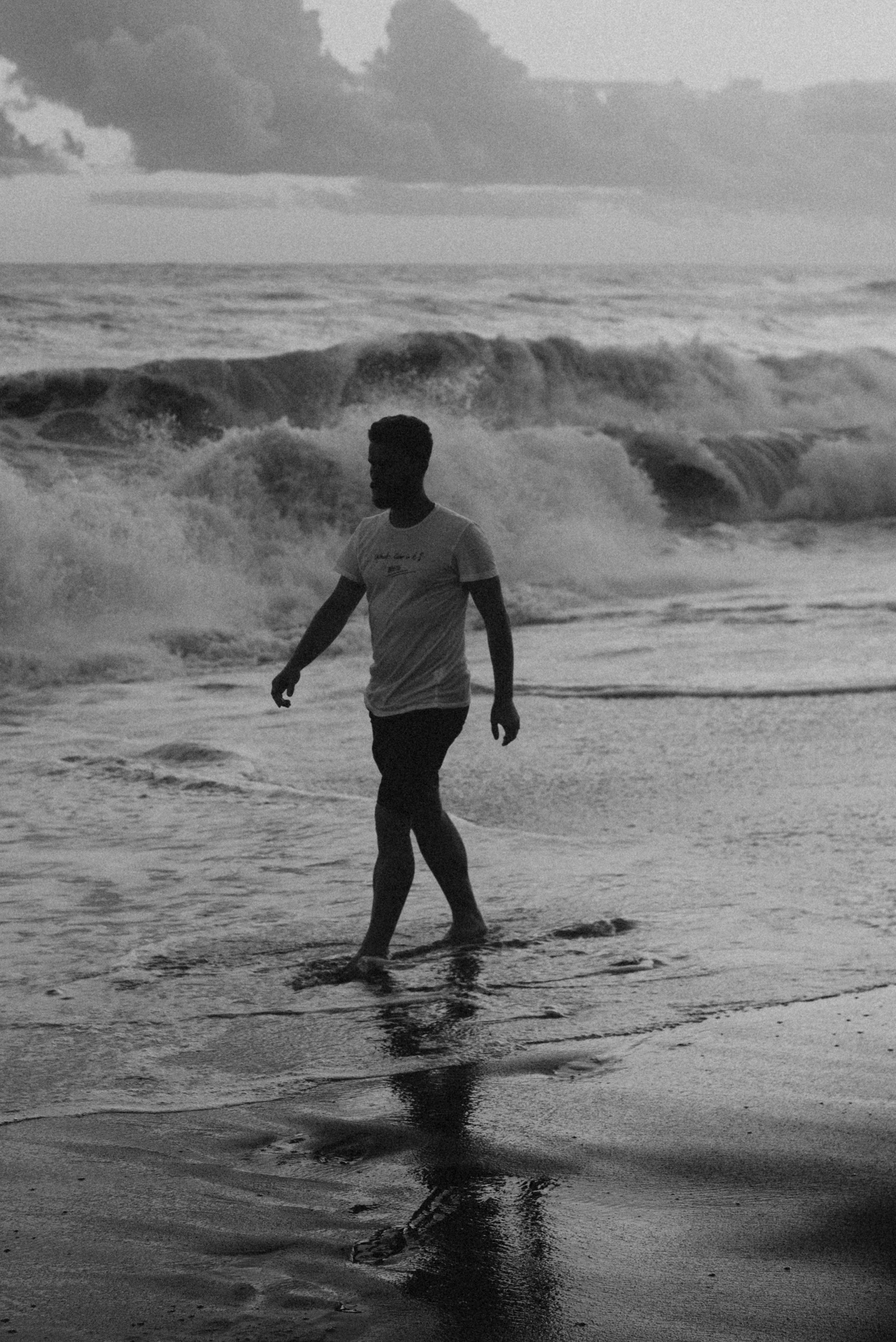a man standing on top of a beach next to the ocean