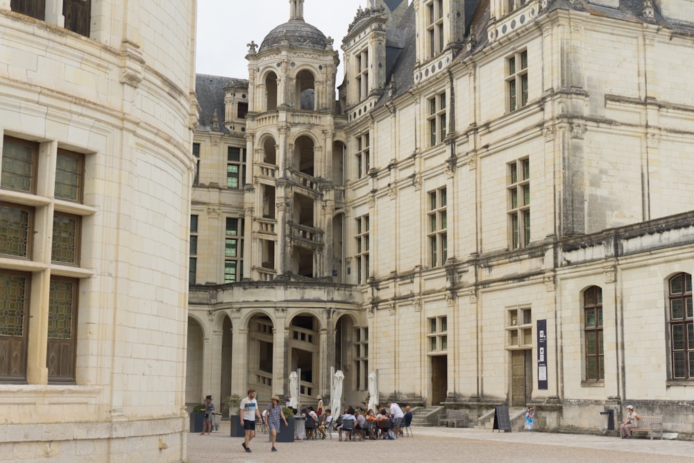 a group of people standing in front of a large building