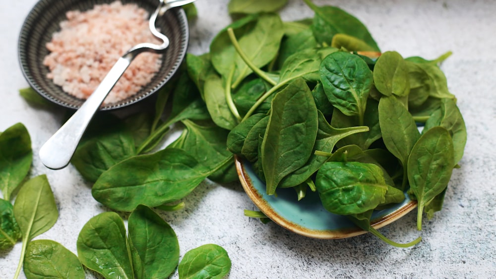 a plate of spinach and a bowl of rice