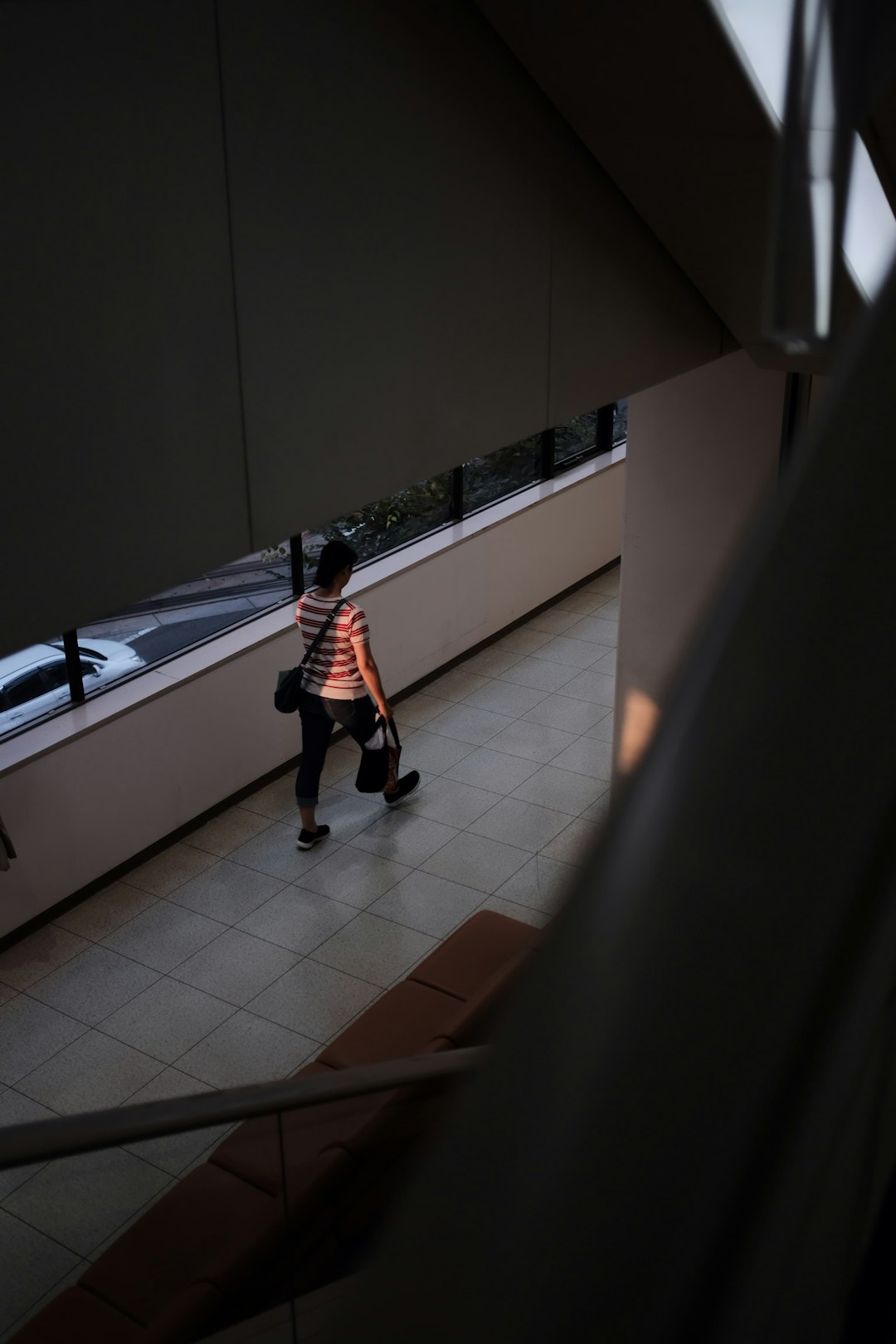walking person in striped shirt carrying bag