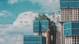 a group of tall buildings under a cloudy blue sky