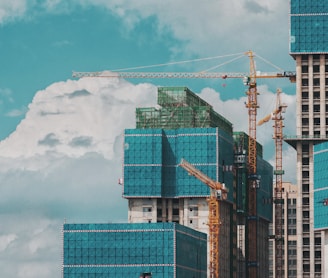 a group of tall buildings under a cloudy blue sky