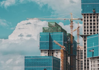 a group of tall buildings under a cloudy blue sky