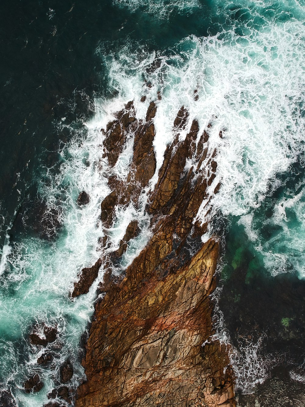 a bird's eye view of the ocean and rocks