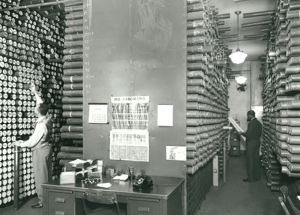 a woman standing in a room filled with stacks of cans